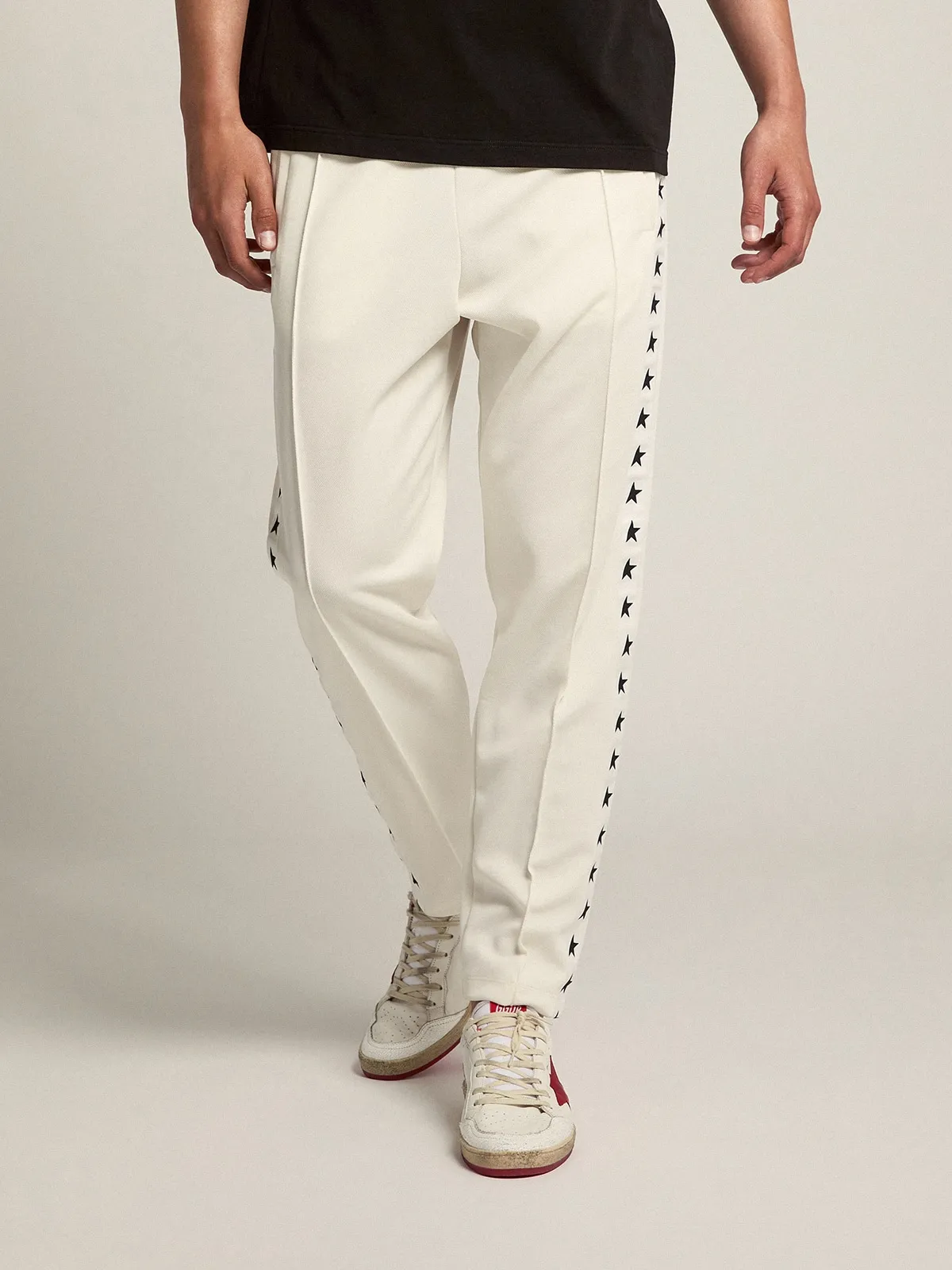 Men's white joggers with black stars on the sides